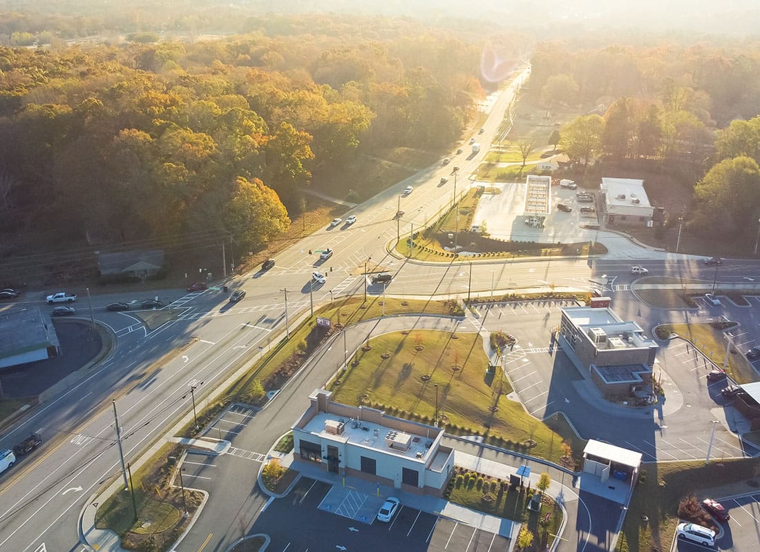 Buford, GA - Aerial View of a Gas Station and Other Buildings Surrounded by Trees by a Highway on a Sunny Day in Buford Georgia